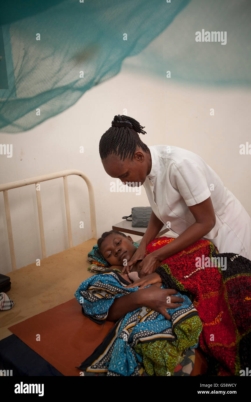 Eine Krankenschwester kümmert sich um ihr neugeborenes Baby in Kigoma Region, Tansania und Patienten. Stockfoto