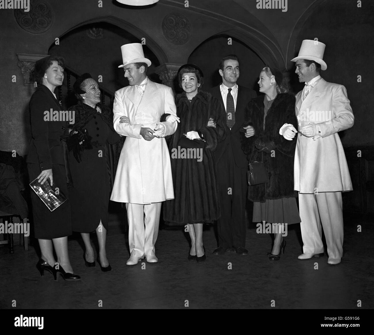 Der britische Filmschauspieler Michael Wilding neckt die amerikanische Schauspielerin Gloria Swanson in der "Floradora"-Nummer "Tell Me, Pretty Maiden" im Empire Theatre, Leicester Square, London, während der Abschlussproben für die Royal Film Performance. Von links nach rechts; Jean Kent, Gloria Swanson, Michael Wilding, Claudette Colbert, Montgomery Clift, Pat Dainton und Richard Todd Stockfoto