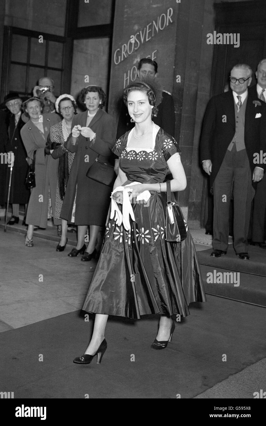 Prinzessin Margaret, in einem Kleid mit großen Gänseblümchen-Ketten und einem kleinen Hut mit großen fächerförmigen Rüschen verziert, als sie verließ Grosvenor House, London. Stockfoto