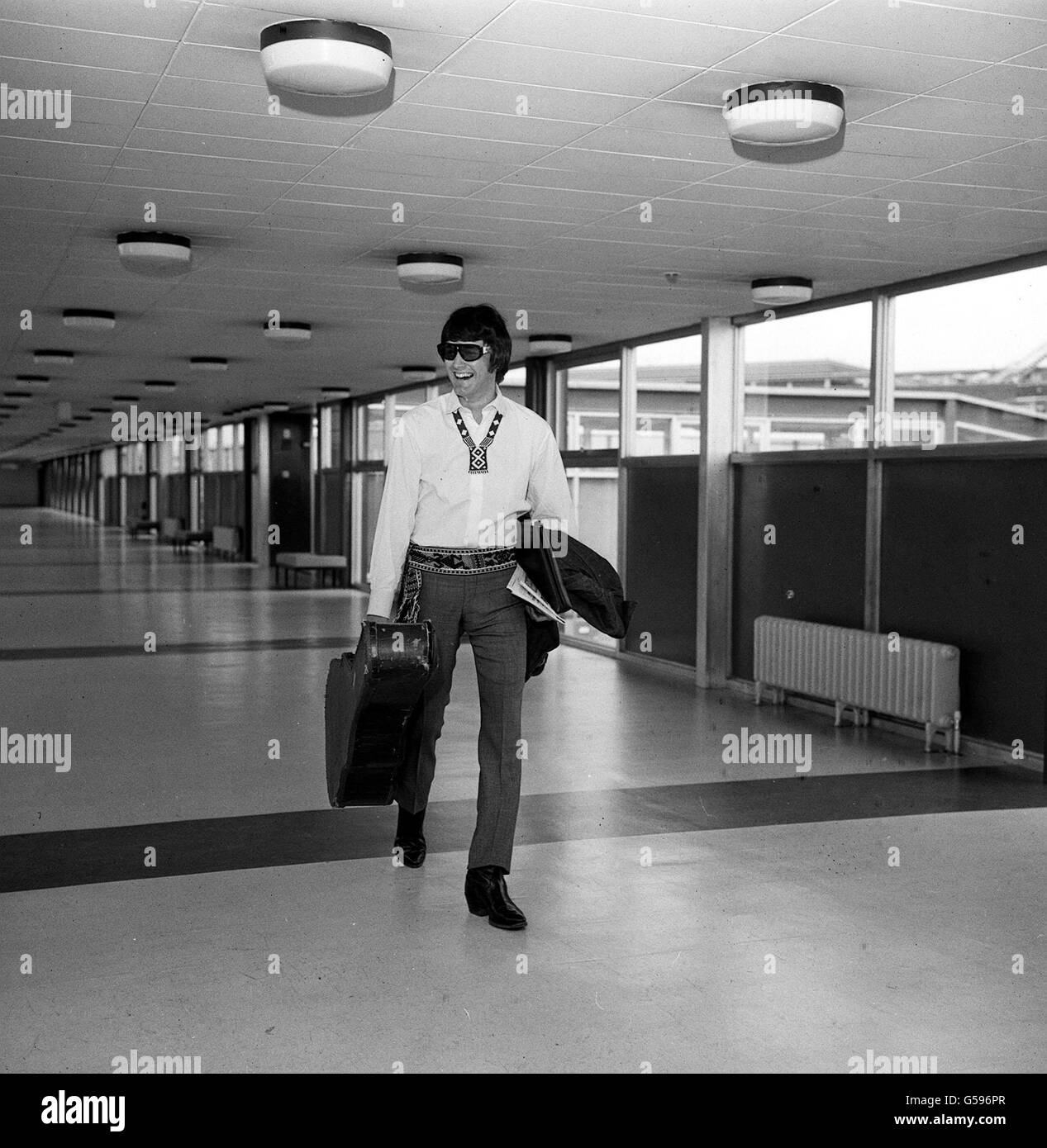 Der amerikanische Sänger PJ Proby, der eine kunstvolle Halskette zu seinem Tasseled-Gürtel trug, verließ den Flughafen Heathrow, um an einem Musikfestival in Prag, Tschechoslowakei, teilzunehmen. Stockfoto