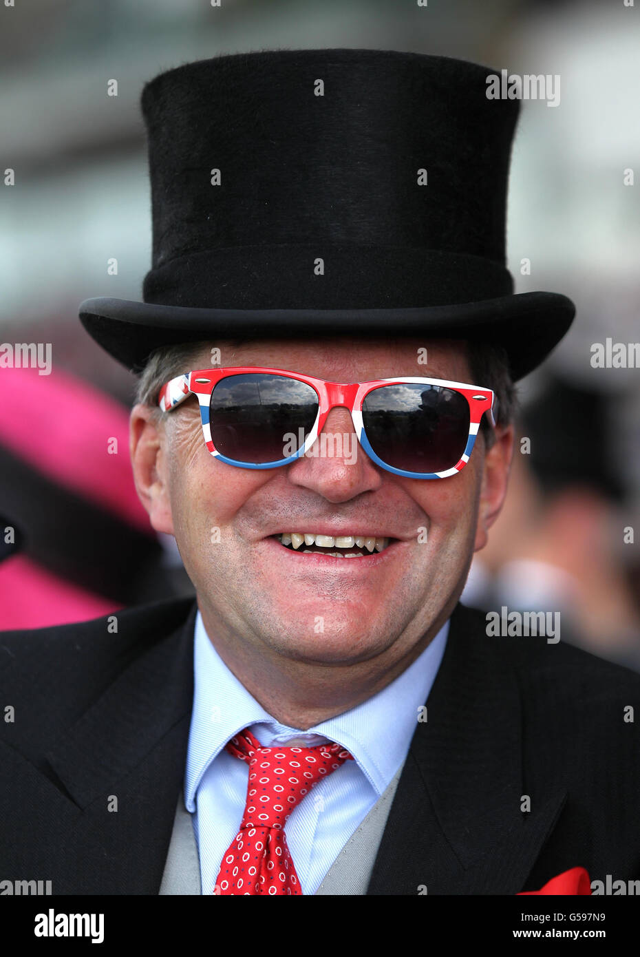 Ein Rennegoist, der am dritten Tag des Royal Ascot-Treffens 2012 auf der Ascot Racecourse, Berkshire, eine Union Jack-Sonnenbrille trägt. Stockfoto