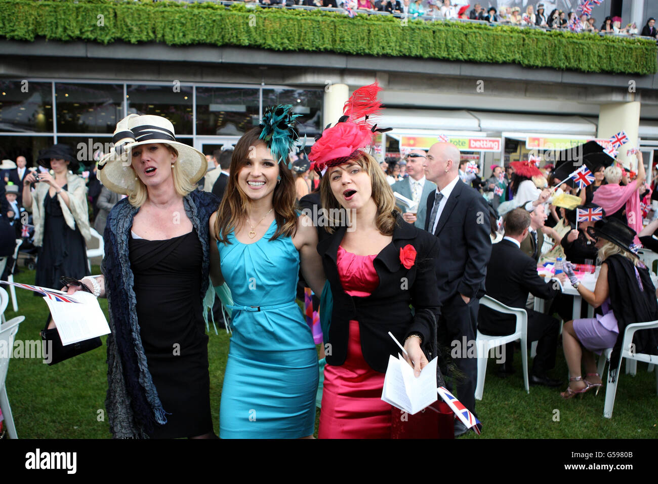 Pferderennen - The Royal Ascot Meeting 2012 - Tag Drei - Ascot Racecourse. Racegoers singen gern am dritten Tag des Royal Ascot Meetings 2012 auf der Ascot Racecourse, Berkshire, um den Bandstand herum. Stockfoto