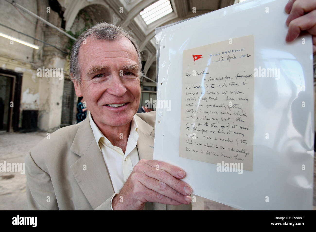 Dr. John Martin der Urneffe von Dr. John Simpson, der auf der Titanic umkam, hält einen Brief von der Titanic in den alten Salon von Harland und Wolff, der diesen Sommer im neuen Besucherzentrum in Belfast, das dem Linienschiff gewidmet ist, ausgestellt wird. Stockfoto