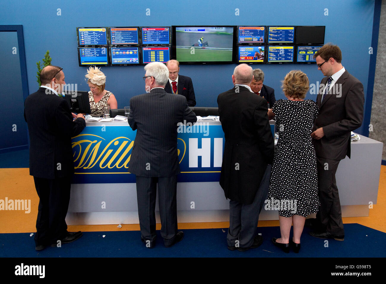 Rennegoer erhalten ihre Wetten im William Hill Festzelt auf der Epsom Racecourse. Stockfoto