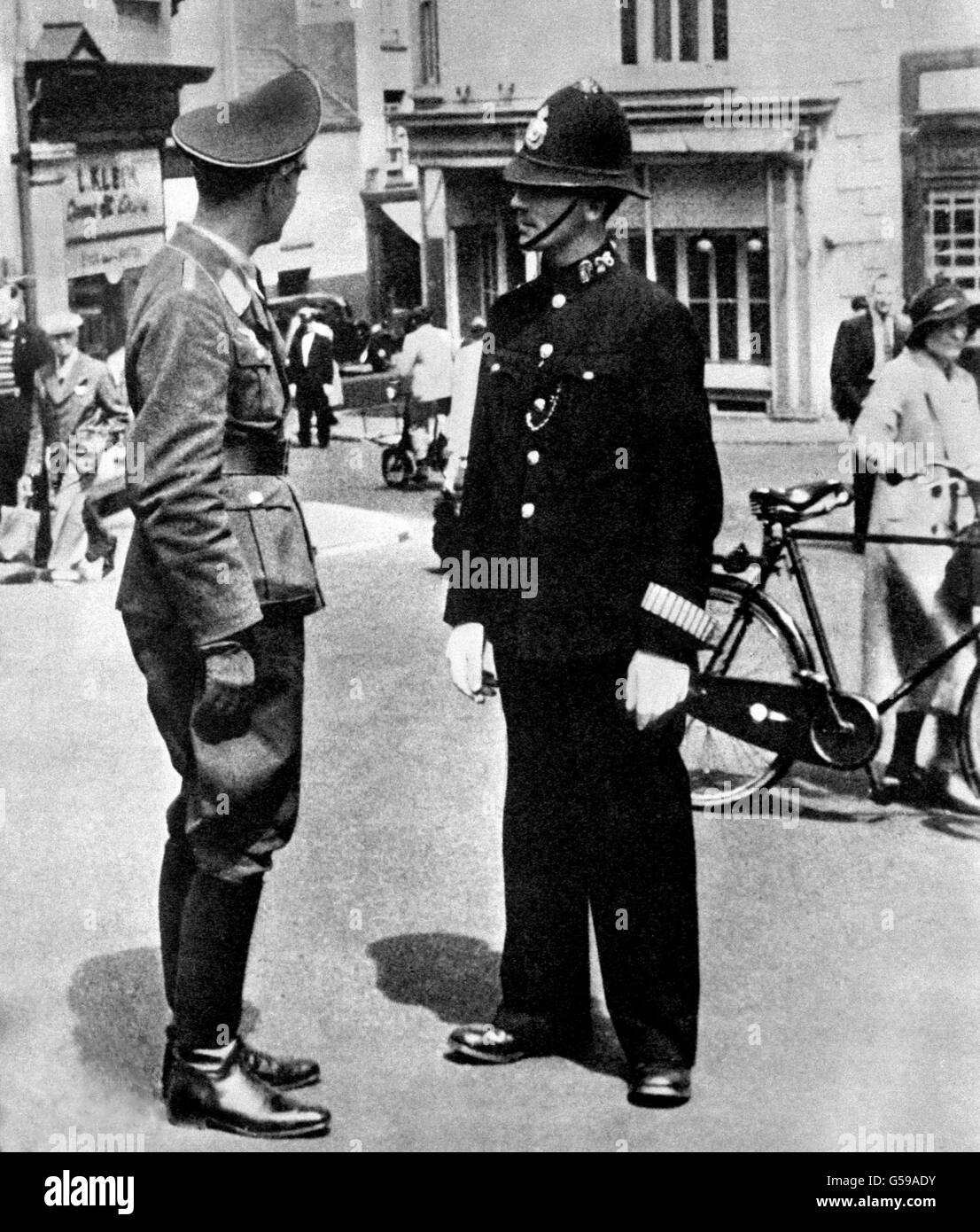 Ein Offizier der Luftwaffe, der während der deutschen Besetzung der Kanalinseln mit einem britischen Polizisten in St. Helier, der Hauptstadt der Insel Jersey, sprach. Stockfoto