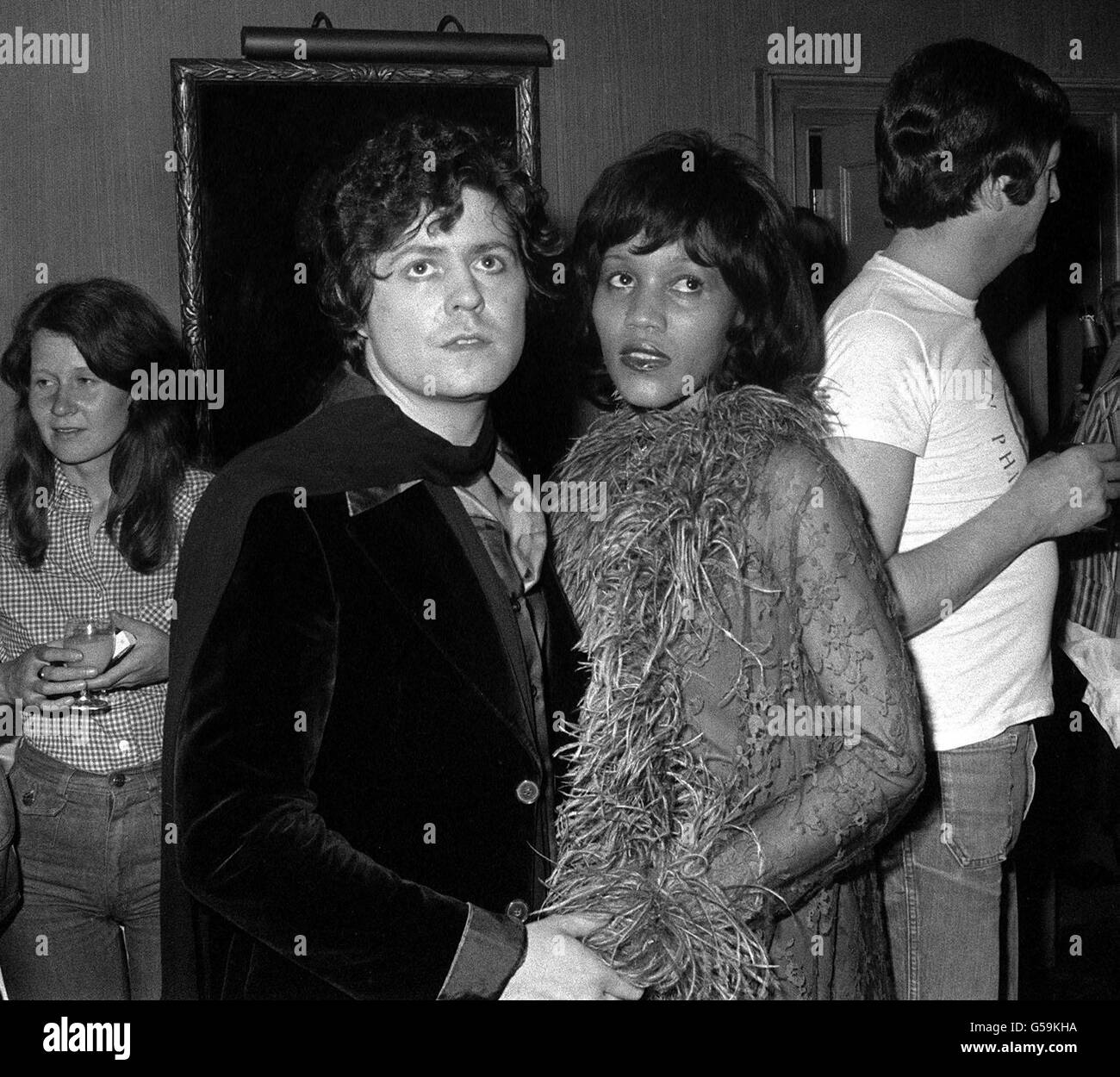 16. SEPTEMBER: Mark Bolan starb an diesem Tag im Jahr 1977 bei einem Autounfall. Popstar Marc Bolan aus der Gruppe T-Rex und seine Freundin, die amerikanische Sängerin Gloria Jones, bei einer Party, die von seinem Popstar Rod Stewart in London gestürzt wurde. Stockfoto