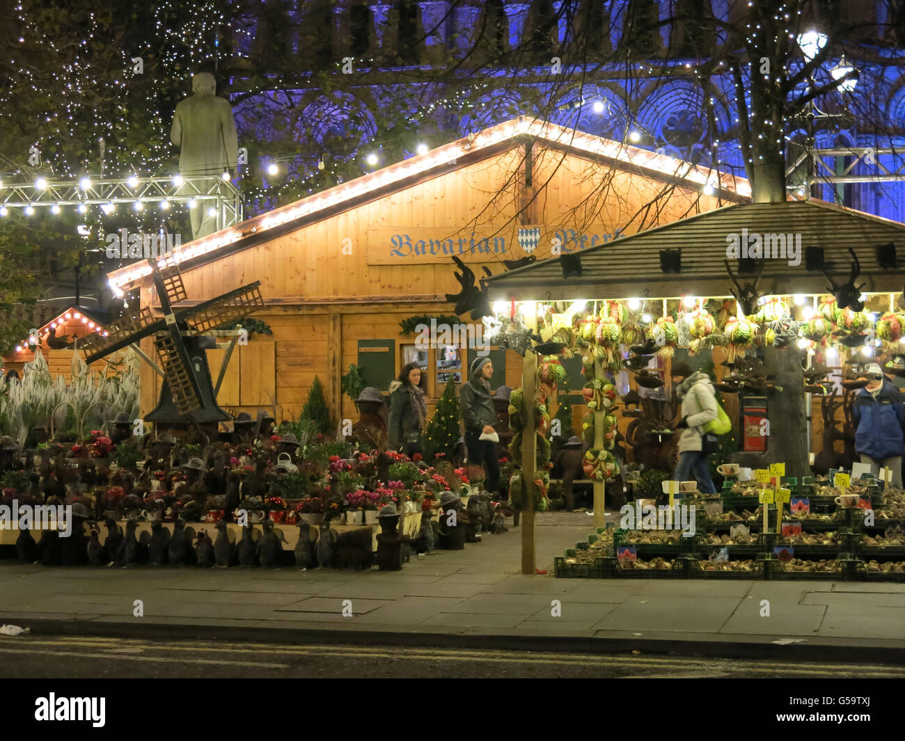 Nachtaufnahme mit Menschen beim Einkaufen am Marktstand am Weihnachtsmarkt in Manchester, England, Vereinigtes Königreich Stockfoto