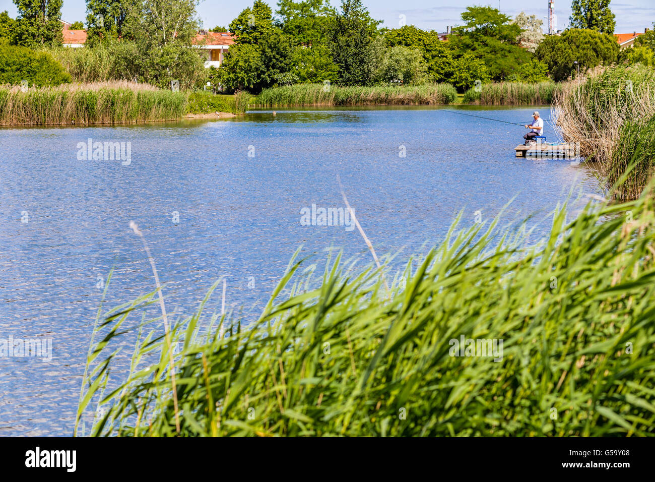 Männer, die in einem künstlichen Teich angeln Stockfoto