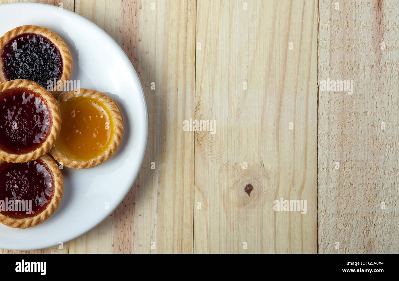 Vor Aufnahme einer Platte von Marmelade Torten auf der linken Seite von einem hölzernen Hintergrund Stockfoto