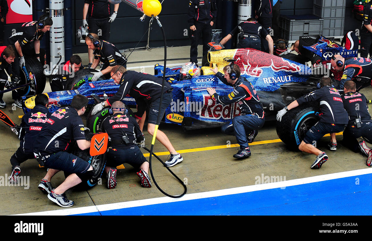Red Bull Racing Renault Sebastian Vettel und die Boxencrew üben einen Boxenstopp während der zweiten Trainingseinheit auf dem Silverstone Circuit in Silverstone. Stockfoto