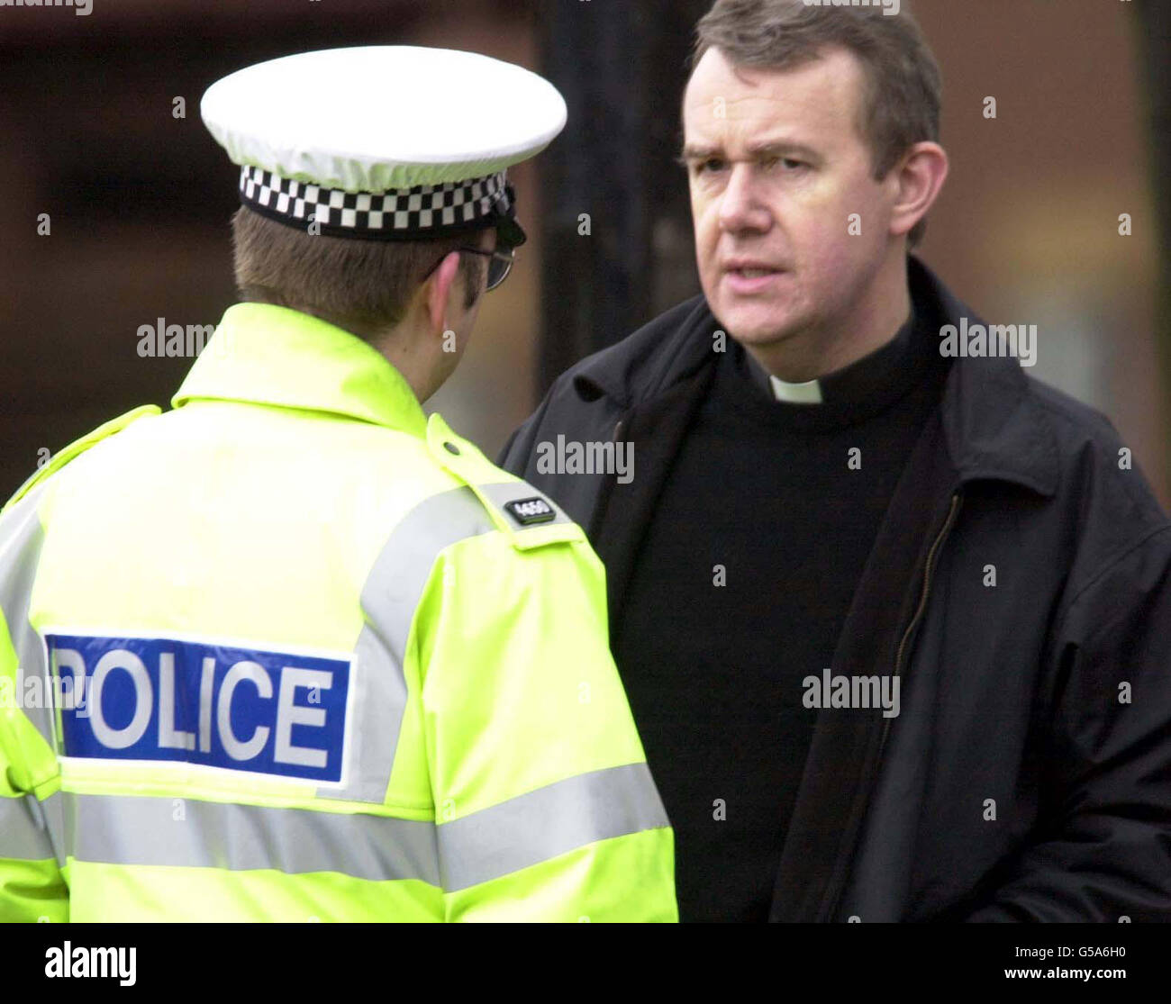 Der örtliche Priester Kevin Patrington spricht mit einem Polizisten im Pontefract Hospital, wo er den Opfern des Eisenbahnunglücks in der Nähe von Selby, bei dem 13 Menschen ums Leben kamen, Unterstützung angeboten hatte. * der Unfall ereignete sich, nachdem ein Güterzug mit einem Personenzug kollidierte, der von einem auf der Strecke gefallenen Kraftfahrzeug entgleist worden war. Stockfoto