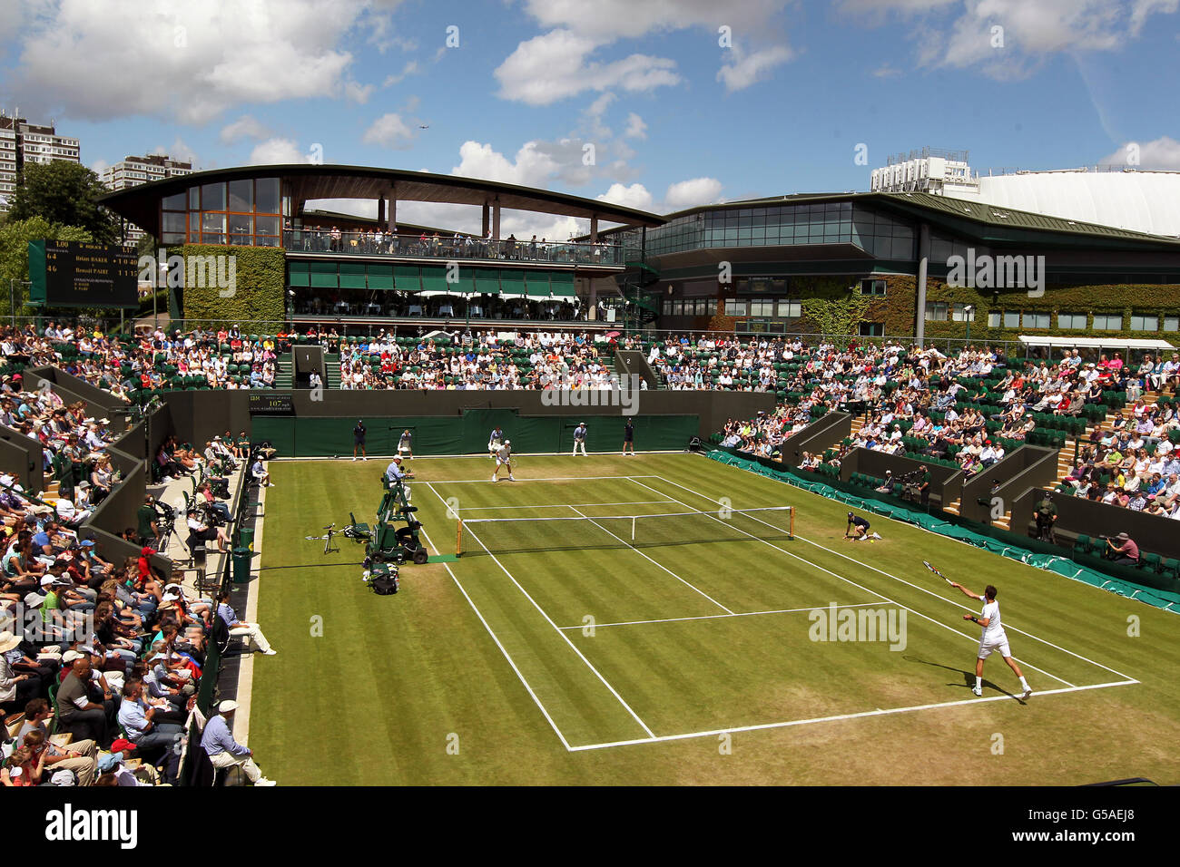 Tennis - Wimbledon Championships 2012 - Tag sechs - All England Lawn Tennis und Croquet Club. Allgemeiner Blick auf die Klage vor Gericht Nummer drei, als der US-amerikanische Brian Baker gegen den französischen Benoit Paire (Nearside) handelt Stockfoto