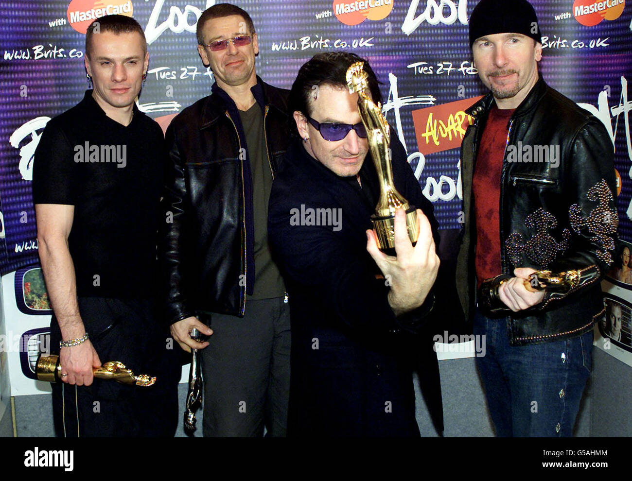 U2-Leadsänger Bono (2R) hält eine Trophäe entgegen, während die Bandmitglieder Larry Mullen Jr (L), Adam Clayton (2L) und The Edge (R) nach dem Gewinn der Best International Group und einer besonderen Auszeichnung für Lebenswerk während der Briten für sich arbeiten. * ...in der Earls Court Arena in London. Die Brit Awards sind das Äquivalent der britischen Musikindustrie zu den Grammys, der größten und meistverehrten Preisverleihung des Jahres. Stockfoto