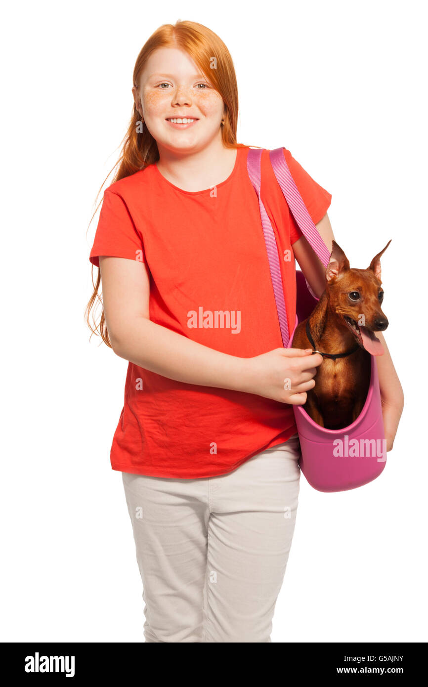 Schönes rotes Mädchen tragen Hund Haustier in Handtasche Stockfoto