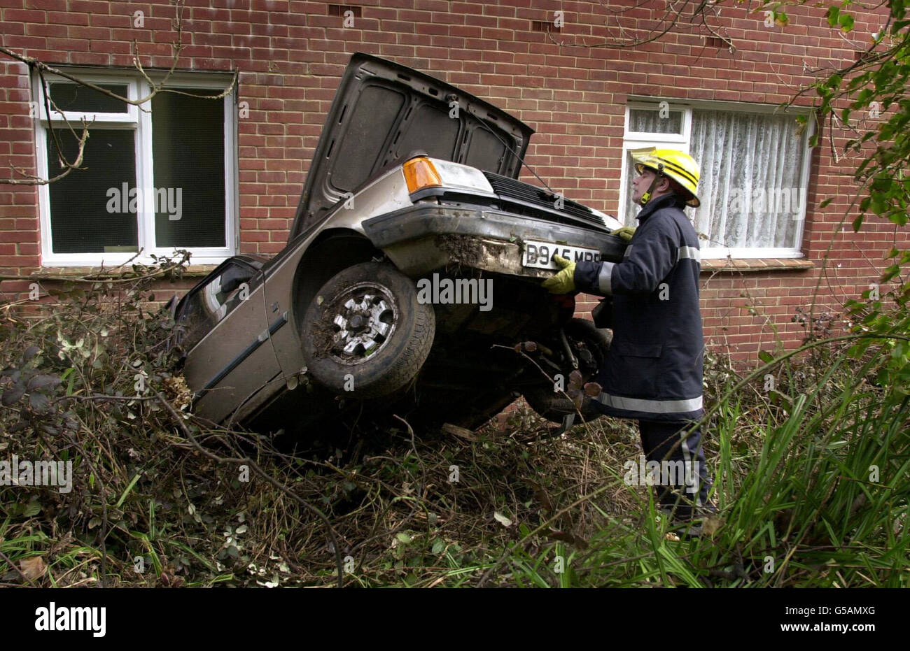 Der Feuerwehrmann Roy Prewitt untersucht nach einem Erdrutsch über Nacht ein Auto, das direkt in die Rückwand des hinteren Parkplatzes des Shanklin Esplanade Hotels in Shanklin, Isle of Wight, geschoben wurde. Sechs Menschen wurden verletzt, als ein 6,000 Tonnen schwerer Schlammlawine das Strandhotel traf. * die Rutsche ereignete sich gestern Abend um 21.25 Uhr, als Teile der 150 Meter hohen Felswand auseinander fielen und in die Rückseite des Shanklin Beach Hotels fielen. Stockfoto