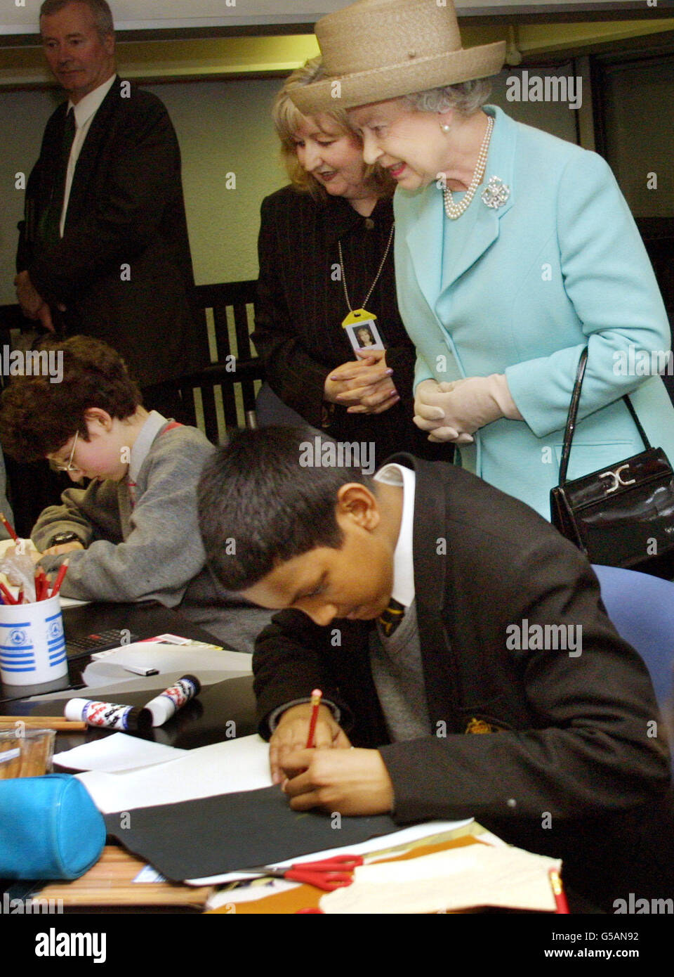 Queen Elizabeth II blickt Kindern beim Besuch der Pimlico Library in London über die Schulter. Sie besuchte die Bibliothek als Teil eines 'Buch-Themen' Tages, wo sie berühmte Autoren traf. * ... besuchte eine Buchhandlung und Verlage, bevor sie in der öffentlichen Bibliothek zu Ende ging. Stockfoto