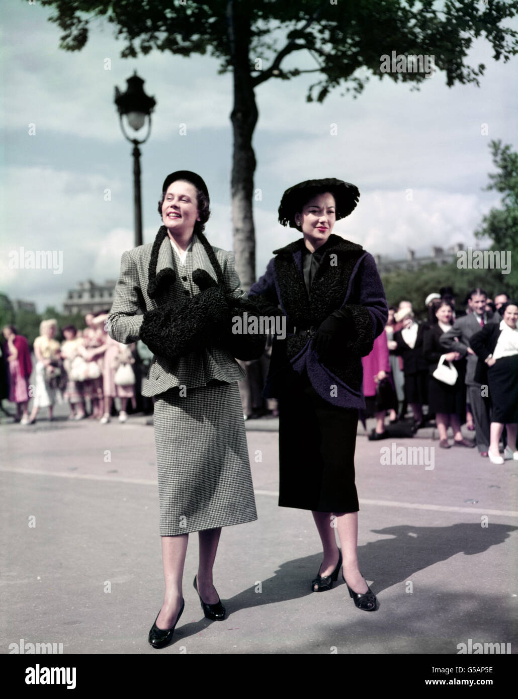 MODE DER 50ER JAHRE 1951: Zwei Wollmodelle von Nina Ricci aus Paris, links ist 'Rosa Bonheur', ein schwarz-weißer Karo-Anzug mit astrachan-Einfassung, und rechts 'La Valliere', eine violett-blaue Jacke mit astrachan-Einfassung, die über einem geraden schwarzen Rock getragen wird. Stockfoto