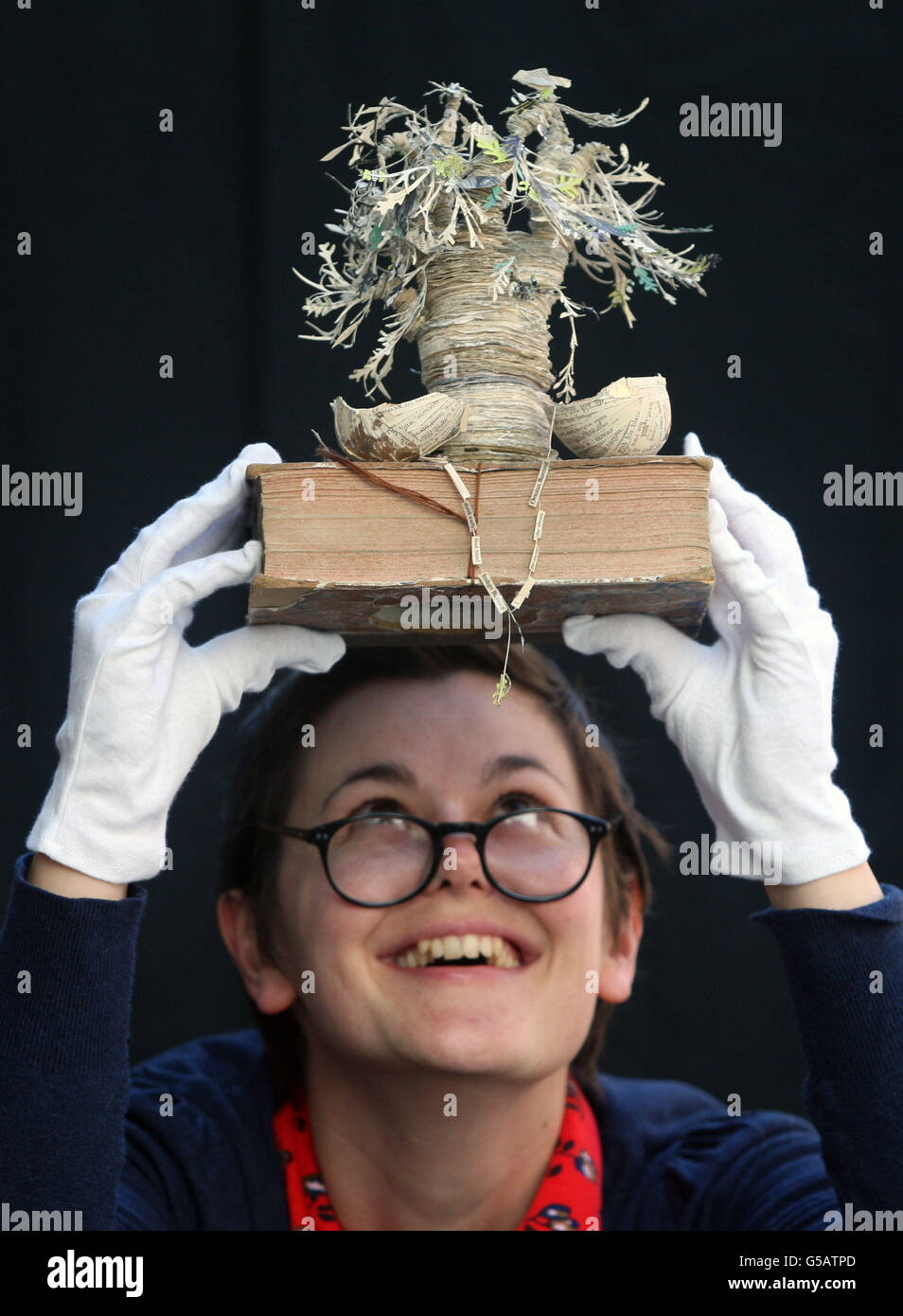 Peggy Hughes, aus Edinburgh City of Literature Trust, betrachtet eine Sammlung von Papierskulpturen auf einer landesweiten Tour durch Bibliotheken, die in der Scottish Poetry Library in Edinburgh zu sehen waren. Stockfoto