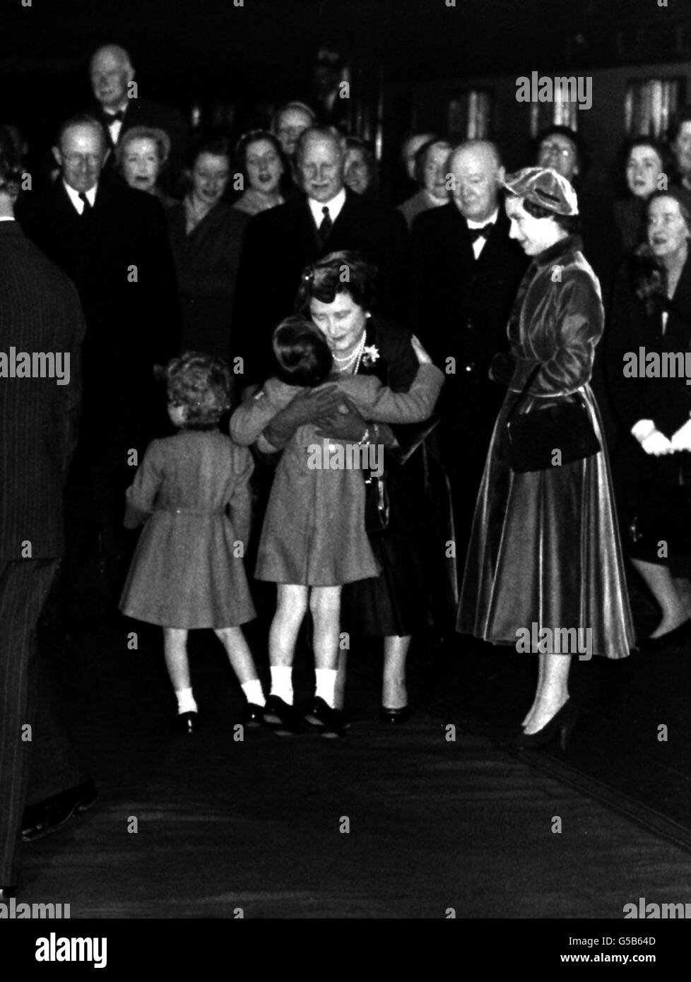 1954: Die Königin Mutter hält ihren Enkel, Prinz Charles, in einer engen Umarmung, die er erwiderte. Die Queen Mother war dabei, am Bahnhof Waterloo nach Southampton zu steigen und eine Reise in die USA und Kanada zu Unternehmen. Es gab auch (l-r) Prinzessin Anne, Sir Winston Churchill und Prinzessin Margaret. Stockfoto