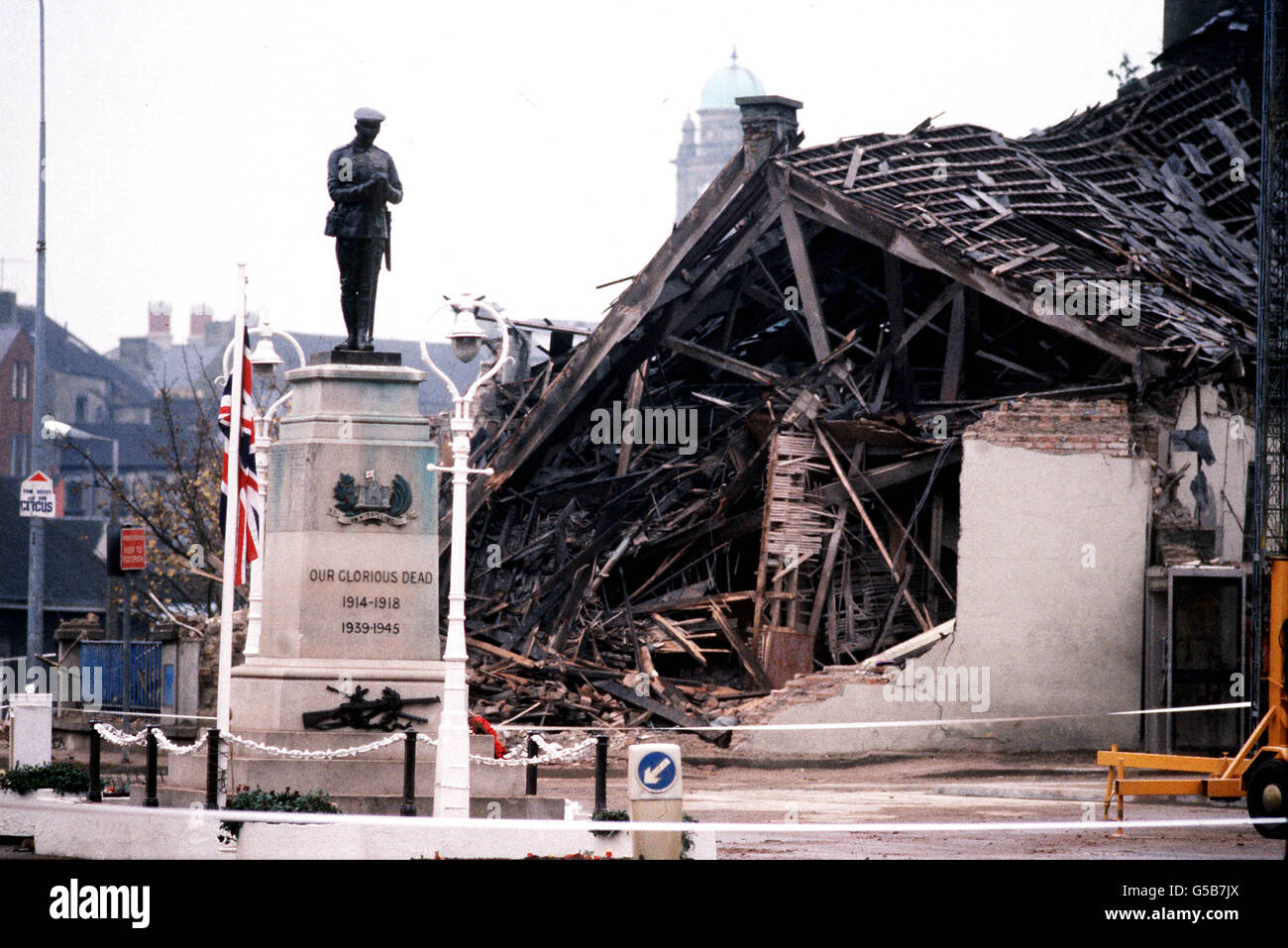 1987: Das Cenotaph in Enniskillen mit dem verwüsteten Gemeindezentrum im Hintergrund. 11 Menschen starben und mehr als 50 wurden bei einer massiven IRA-Bombenexplosion verletzt, kurz bevor eine Gedenkfeier in der Grafschaft Fermanagh-Stadt Enniskillen stattfand. *16/07/02 das Cenotaph in Enniskillen mit dem verwüsteten Gemeindezentrum im Hintergrund, wo 11 Menschen starben und mehr als 50 bei einer massiven Bombenexplosion der IRA kurz vor einer Gedenkfeier verletzt wurden. Die IRA hat sich am Freitag, den 16. Juli 2002, für die Ermordung aller "nicht-Kämpfer" entschuldigt, die während ihrer Terrorkampagne ums Leben kamen. Stockfoto