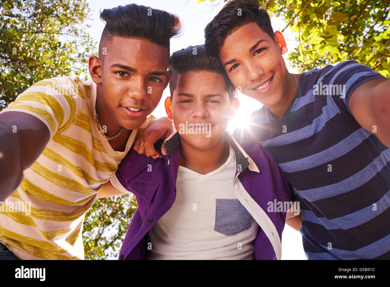Jugendkultur, multi-ethnischen Teens im freien umarmen und glücklich in die Kamera schauen. Stockfoto
