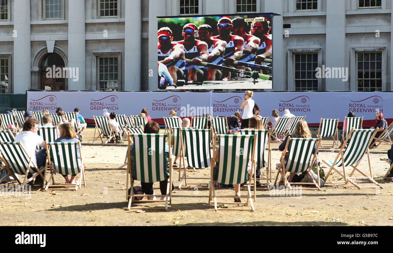 Olympische Spiele In London - Tag 3. Zuschauer beobachten die Olympischen Spiele auf einer Großleinwand im Royal Naval College in London. Stockfoto