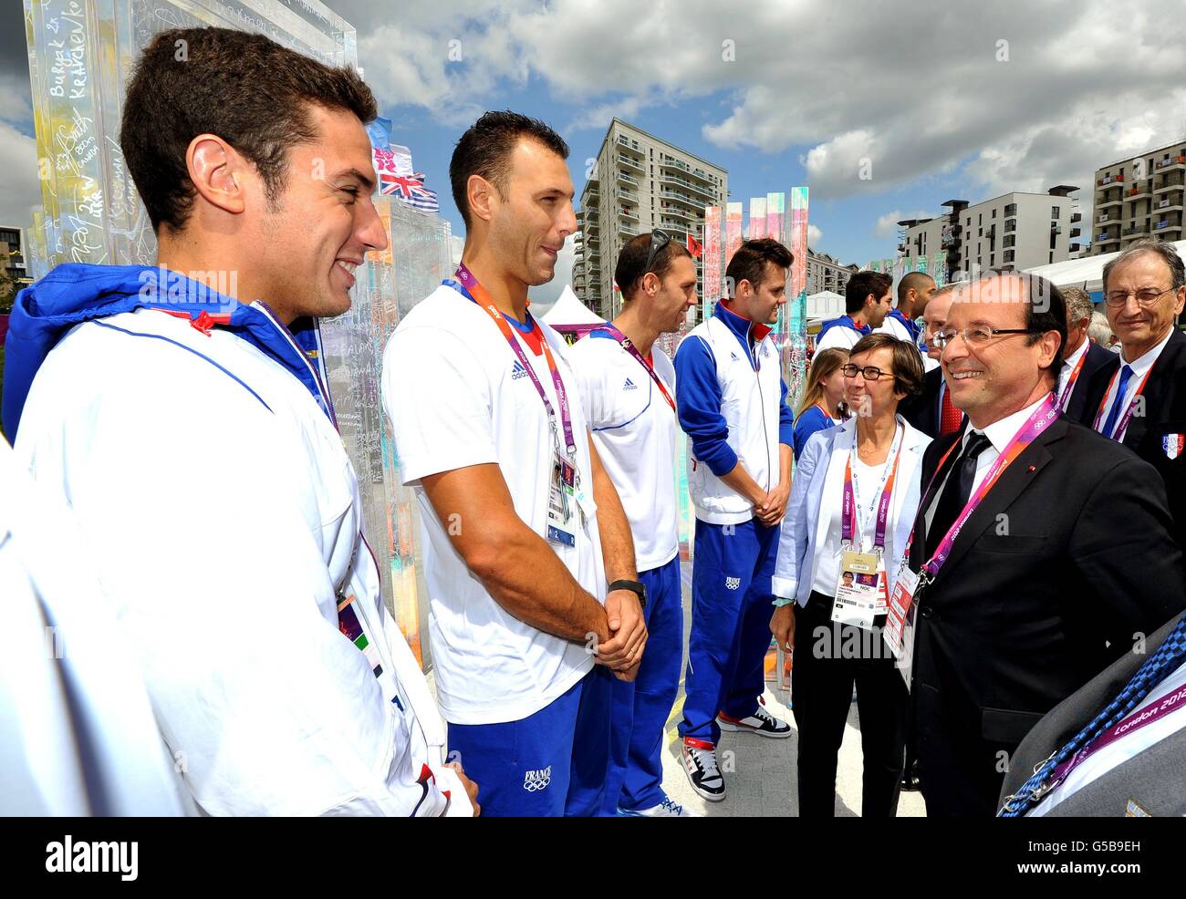 Frankreichs Präsident Francois Hollande spricht mit Mitgliedern der französischen Basketballmannschaft (Namen nicht angegeben) während der Reise des Präsidenten in das Dorf der Olympischen Athleten in Stratford, Ost-London. Stockfoto