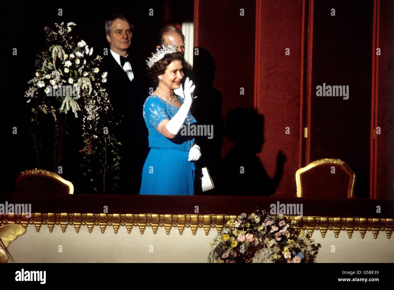 Königin Elizabeth II. Winkt dem Publikum aus der Royal Box, als sie im Rahmen ihrer 60. Geburtstagsfeier im Royal Opera House, Covent Garden, London, eintreffen wird. Unmittelbar hinter ihr steht der Herzog von Edinburgh. Stockfoto