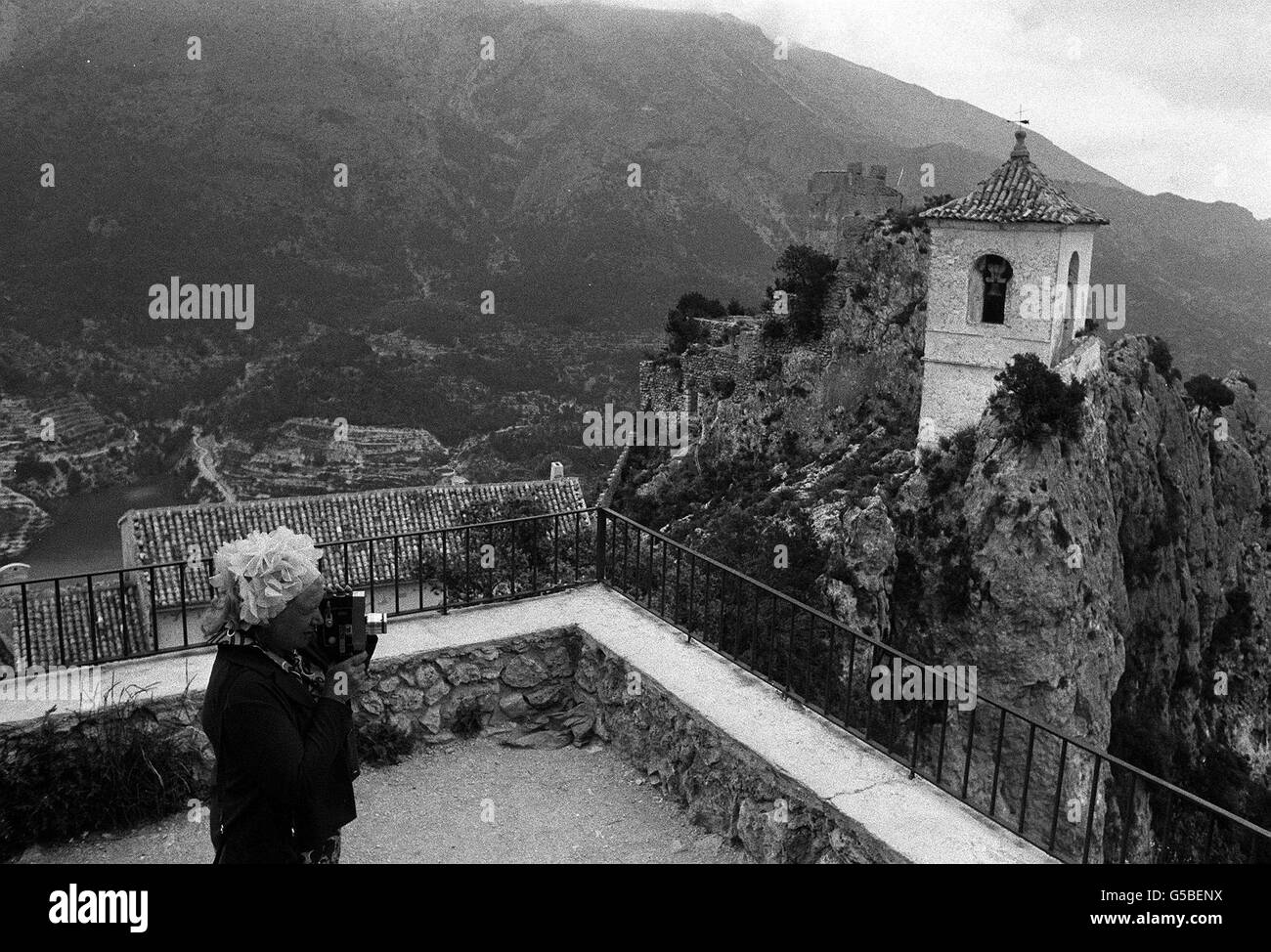 Das kleine Dorf Guadalest, das hoch in den Bergen thront, ist ein beliebtes Motiv für Touristen, die mit der Kamera unterwegs sind. Dieser Tourist ist einer der Tausende, die jedes Jahr den Gipfel mit einem Esel erreichen müssen, um den Kirchturm auf einem der vielen Gipfel zu fotografieren. Stockfoto