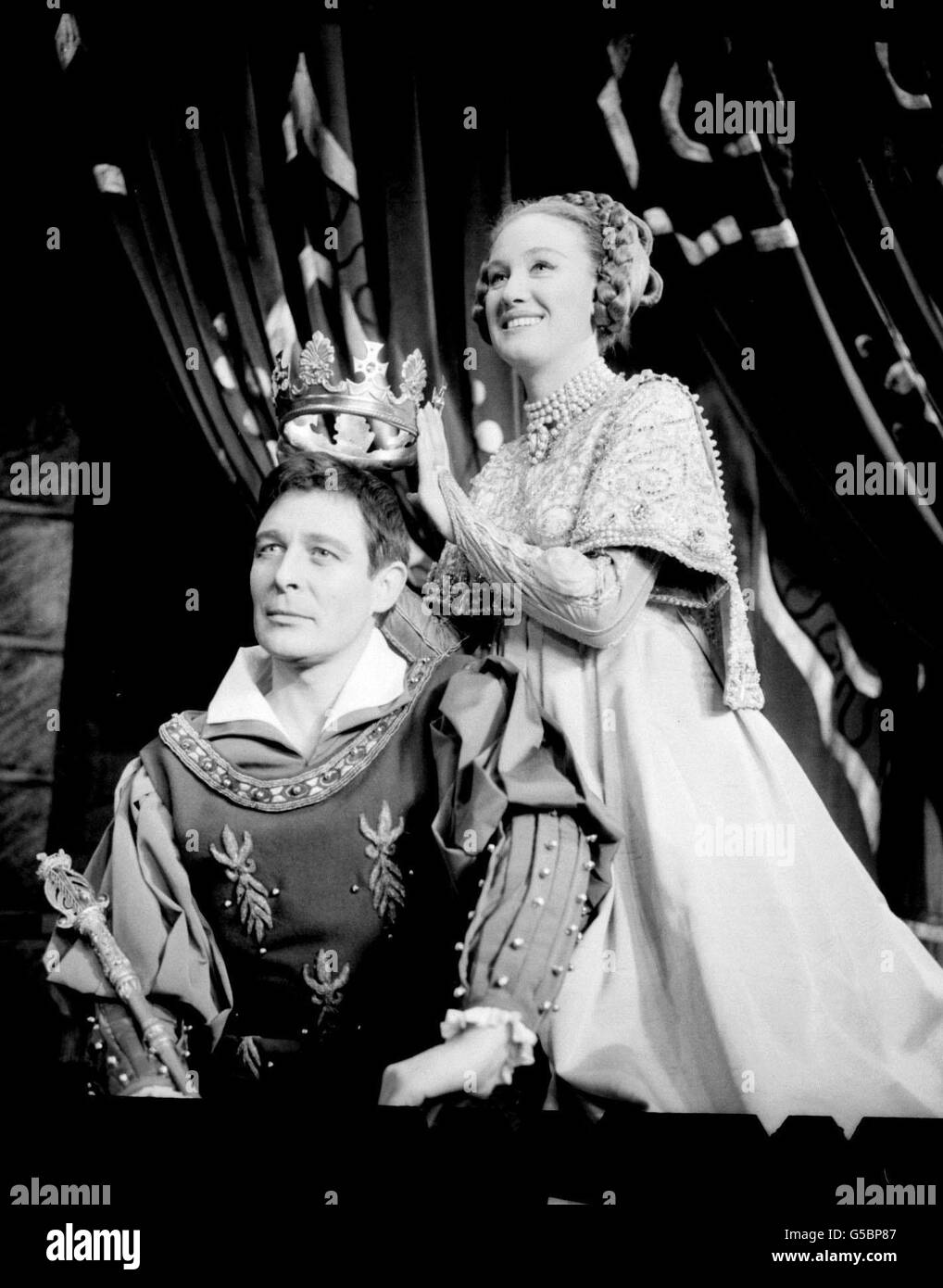Der Schauspieler Paul Daneman spielt King Arthur im Musical Camelot im Theatre Royal, Drury Lane, London und wird von der Hauptdarstellerin Elizabeth Larner in Queen Guinevere gekrönt. Stockfoto