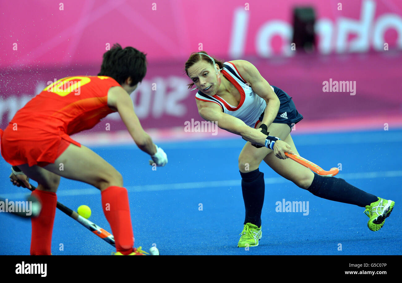 Die britische Kate Walsh, die einen Kieferschutz trägt, und die chinesische Lihua Gao kämpfen während des Eishockeyspiels der Gruppe A in der Riverbank Arena im Olympiapark am achten Tag der Olympischen Spiele in London 2012 um den Ball. Stockfoto
