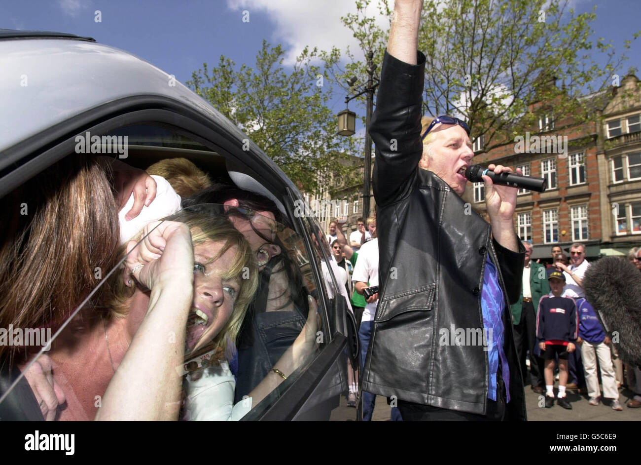 Guinness-Sprecher Dr. Lars Haze kündigt einen Weltrekord an, nachdem sich vierzehn Menschen in einem Smart-Auto, einem der kleinsten Serienwagen auf dem Markt, im Zentrum von Nottingham eingepfercht haben. *... Die vierzehn drehten sich und drehten sich, um sich im Rahmen einer Promotion der Fahrzeughersteller DaimlerChrysler in das Smart-Auto zu verwandeln, und brachen damit den aktuellen Rekord, der 1999 von nur einer Person aufgestellt wurde. Stockfoto