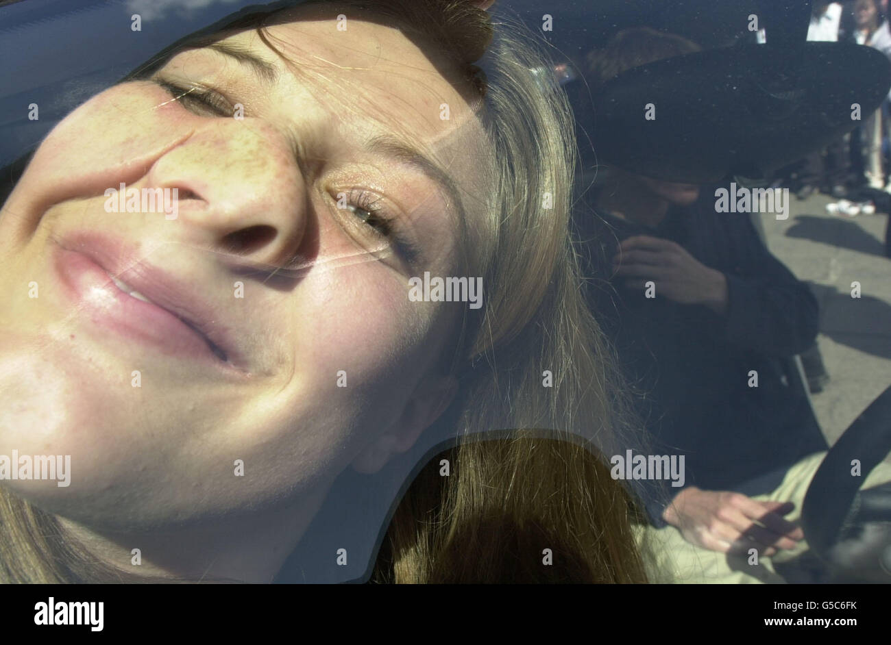 Tara Holland, gequetscht gegen ein Fenster des Autos, als sie und dreizehn andere Menschen sich in einem Smart Auto, einem der kleinsten Serienwagen auf dem Markt, im Zentrum von Nottingham zusammenquetscht. *die vierzehn drehten und drehten sich, um sich in das Smart Auto als Teil einer Förderung der Fahrzeughersteller DaimlerChrysler, brechen die aktuelle Rekord, im Jahr 1999, von nur einer Person. Stockfoto