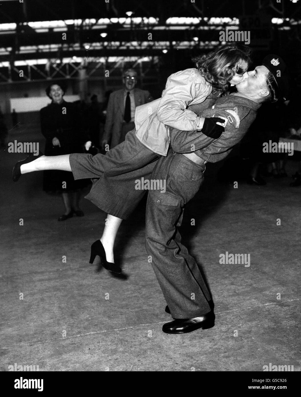 Jean How, 19, wird von ihrem Verlobten, Lance-Corporal Anthony Hardy, von den "Glorious Glosters" von den Füßen weggefegt. Er war einer von etwa 200 ehemaligen koreanischen Kriegsgefangenen, die Southampton im Troopschiff HMT Dunera erreichten. Sie wurden verlobt, während Anthony in einem Gefangenenlager war. Stockfoto