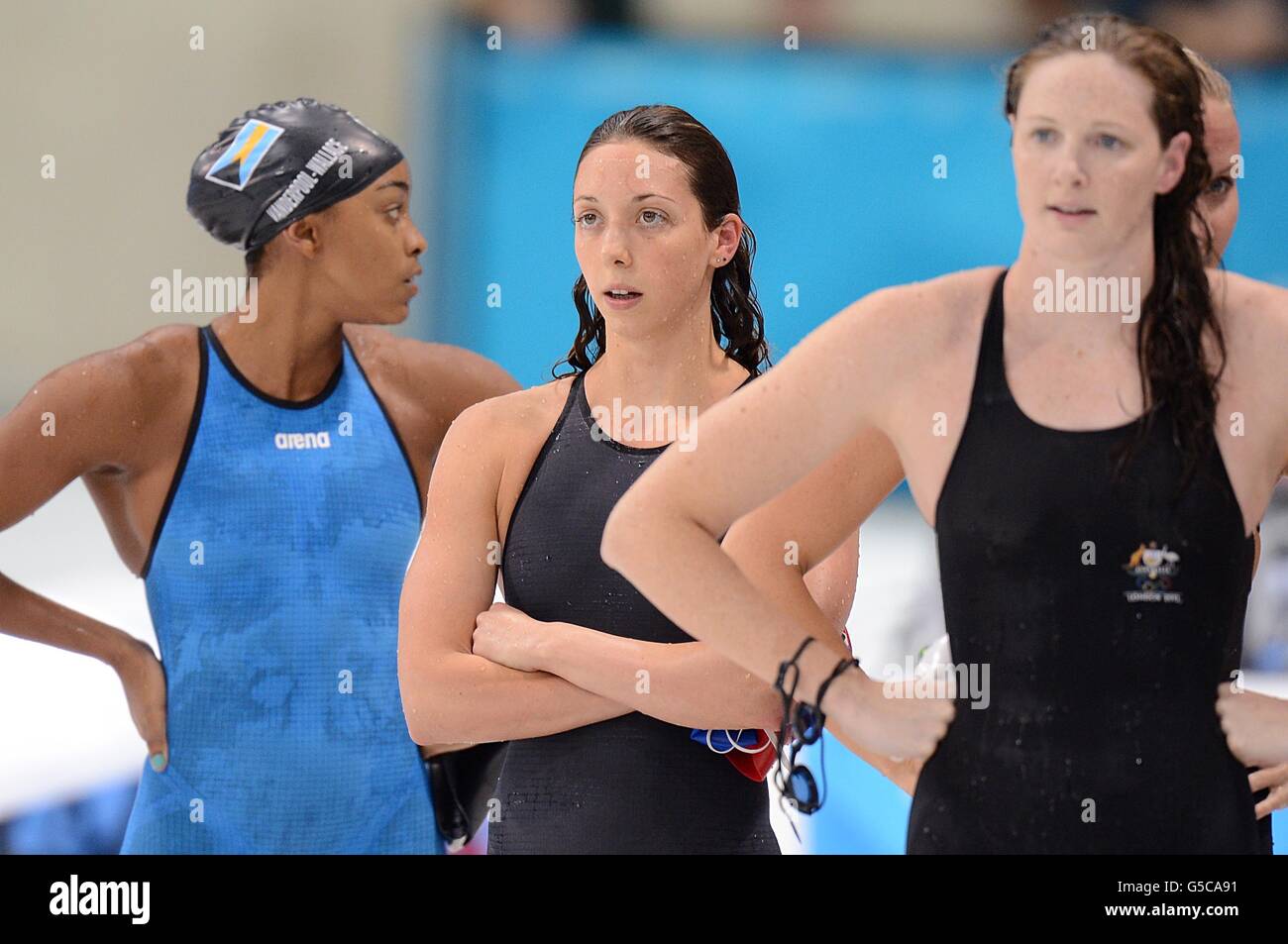 Die britische Amy Smith (Mitte) schaut auf die Ergebnisliste, nachdem sie im Halbfinale 1 im 50-m-Freistil der Frauen im Aquatics Center im Olympic Park, London, am siebten Tag der Olympischen Spiele 2012 in London geschwommen war. Stockfoto