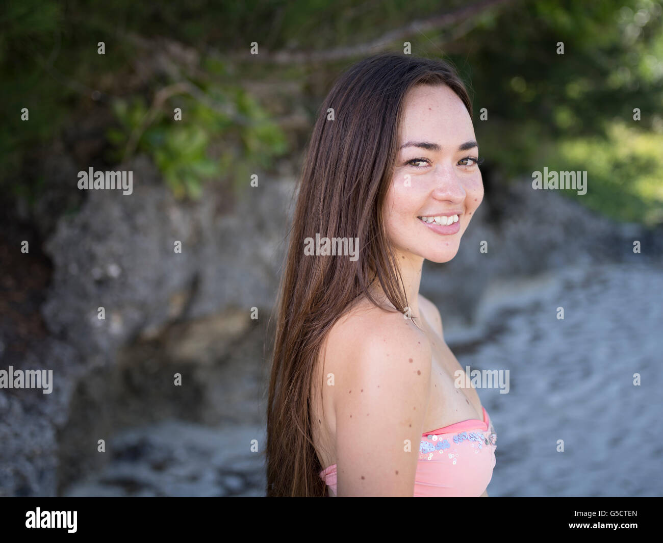 Junge schöne Mischlinge Frau am Strand im Bikini lächelnd Stockfoto