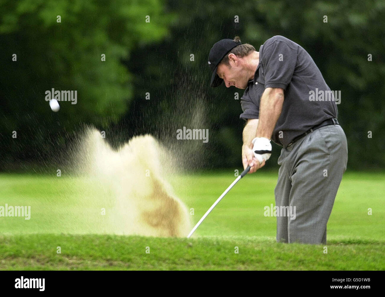 Der englische Nick Faldo schlingt beim dritten Lauf der Volvo PGA Golf Championship in Wentworth aus einem Fairwaybunker auf dem 16. Loch. Stockfoto