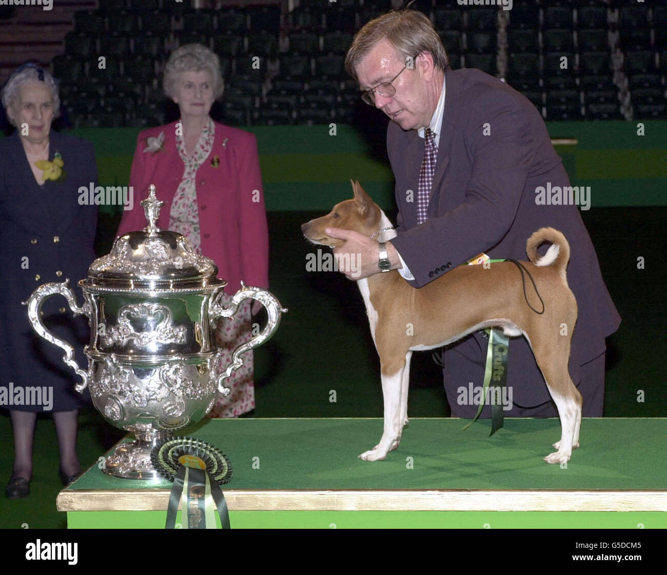 Champion Jethard Cidevant, der Basenji, bekannt als Sid, mit Besitzer Paul Singleton aus Colchester, Essex, nachdem er auf der diesjährigen Cruft Dog Show im Birmingham National Exhibition Centre zum Supreme Champion ernannt wurde. Stockfoto