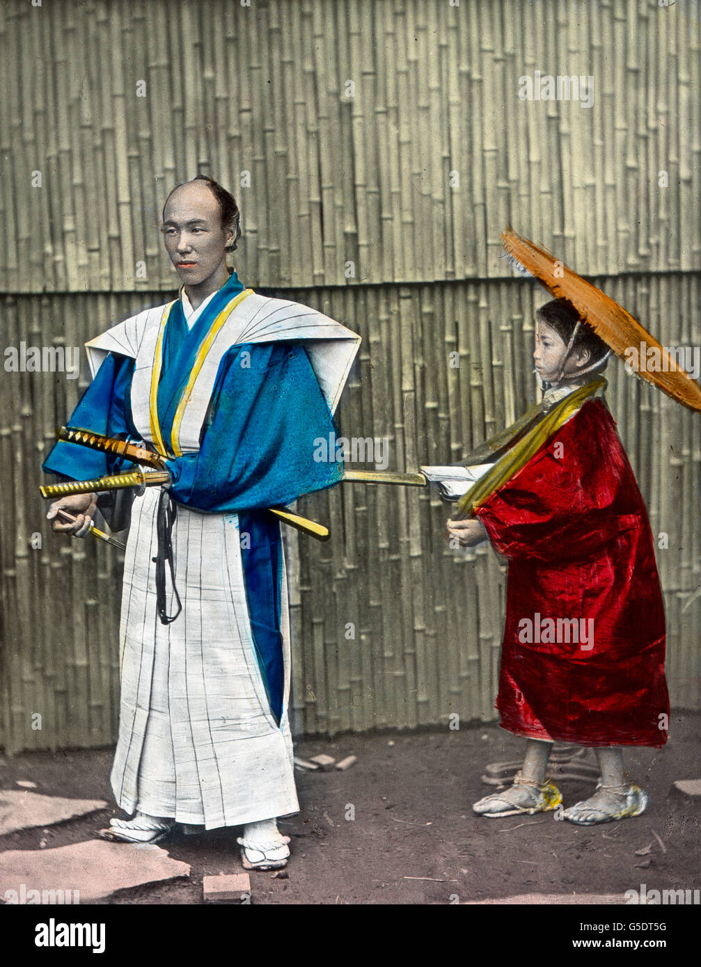 Ein Samurai-Krieger Mit seit Diener.  Asien, Japan, asiatisch, Reisen, 1910er Jahre, 1920er-Jahre des 20. Jahrhunderts, archivieren, Carl Simon, Geschichte, historisch, Japanisch, Samuarai mit Diener, Ritter, Mann, Krieger, Kämpfer, Squire, Kind, junge, Schwert, Hand-farbigen Glas-Folie Stockfoto