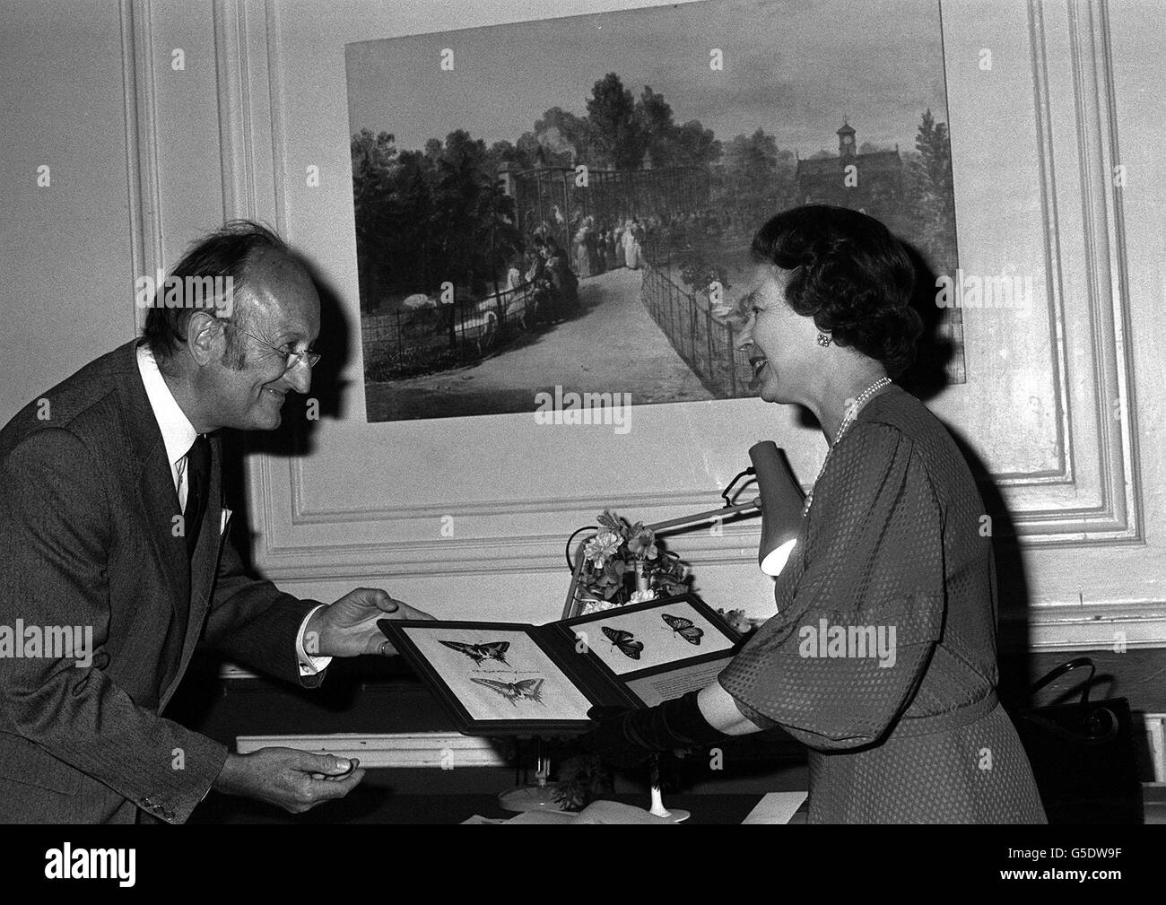 Königin Elizabeth II. Erhält ein Geschenk von Professor Sir Richard Southwood, Präsident der Royal Entomological Society of London, in den Ecological Gardens im Regent's Park, London. Die Königin, die die Schutzpatronin der Gesellschaft ist, überreichte Auszeichnungen, als die Gesellschaft den hundertsten Jahrestag der Erteilung der königlichen Charta feierte. Stockfoto