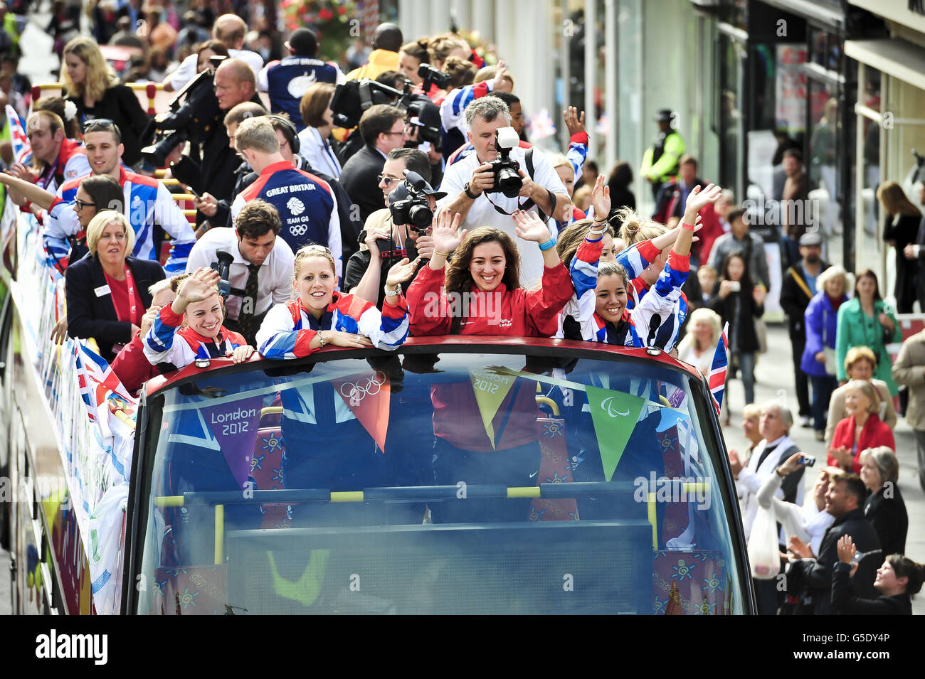 Die Massen jubeln entlang der Milsom Street, während Olympioniken und Paralympier mit einem offenen Bus in ihre Heimatstadt Bath zurückkehren. Stockfoto
