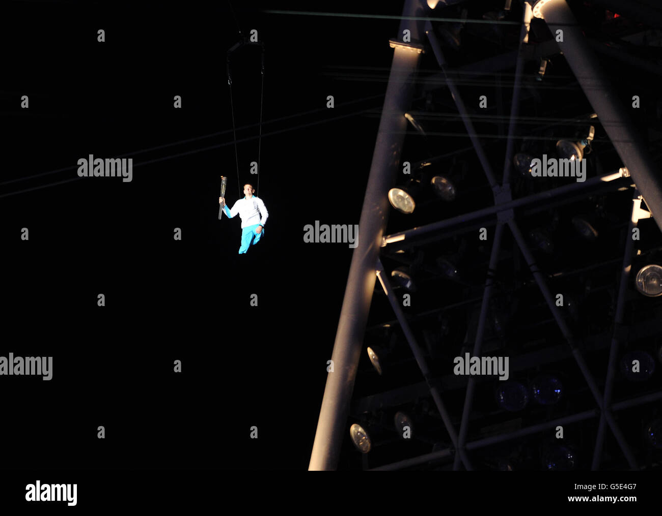 Joe Townsend trägt die paralympische Flamme während der Eröffnungsfeier der Paralympischen Spiele 2012 im Olympiastadion in London auf einem Seildraht aus der Umlaufbahn ins Stadion. Stockfoto