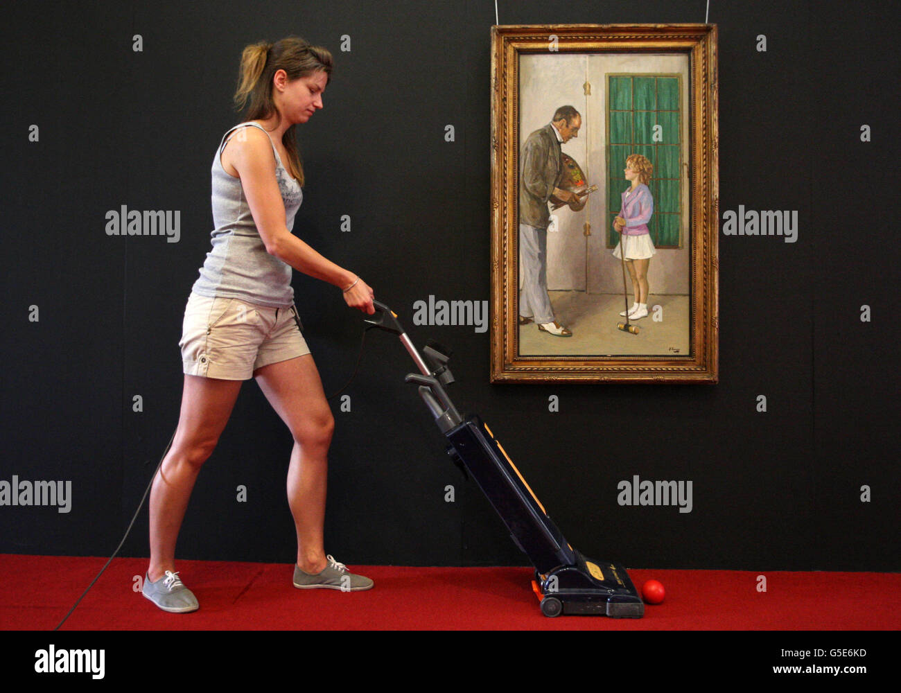 Ein Mitarbeiter von Lyon & Turnbull putzt um ein Gemälde von Shirley Temple von Sir John Lavery, das am Freitag im Auktionshaus Edinburgh zu sehen sein wird. Das Gemälde stammt aus der Heimat des TV-Produzenten Donald Taffner. Stockfoto
