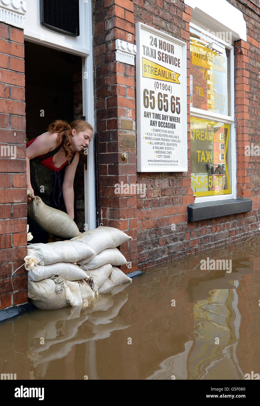 Natalie Stroughair sandbags ein Taxi-Büro in York, während der Fluss Ouse heute nach den sintflutartigen Regenfällen der letzten Tage weiter steigt. Stockfoto