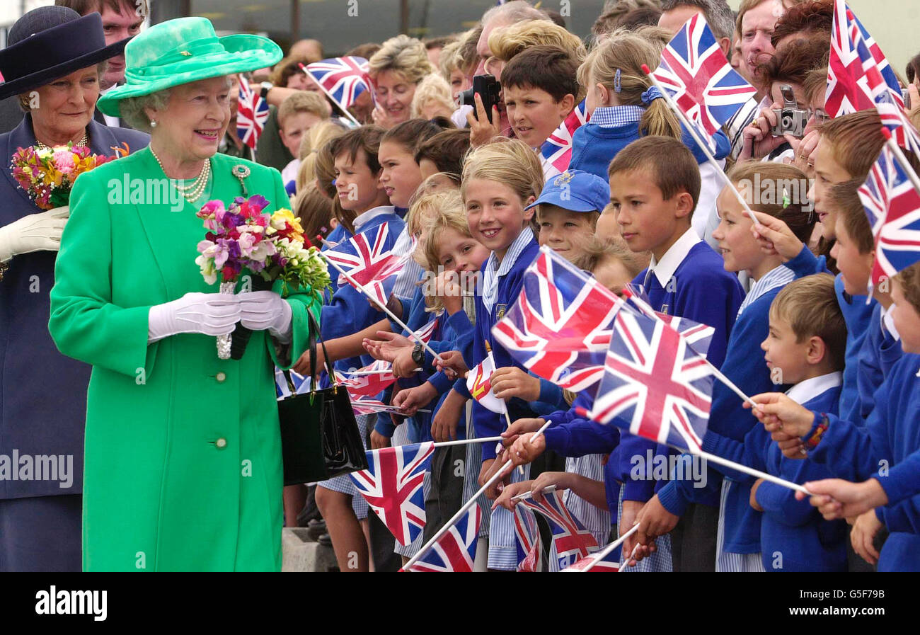 Königin Elizabeth II. Wird am Flughafen Guernsey von Schulkindern zu Beginn eines zweitägigen Staatsbesuchs auf den Kanalinseln begrüßt. In einem apfelgrünen Outfit würdigte die Königin die wartenden Massen mit einer königlichen Welle und einem Lächeln. Stockfoto