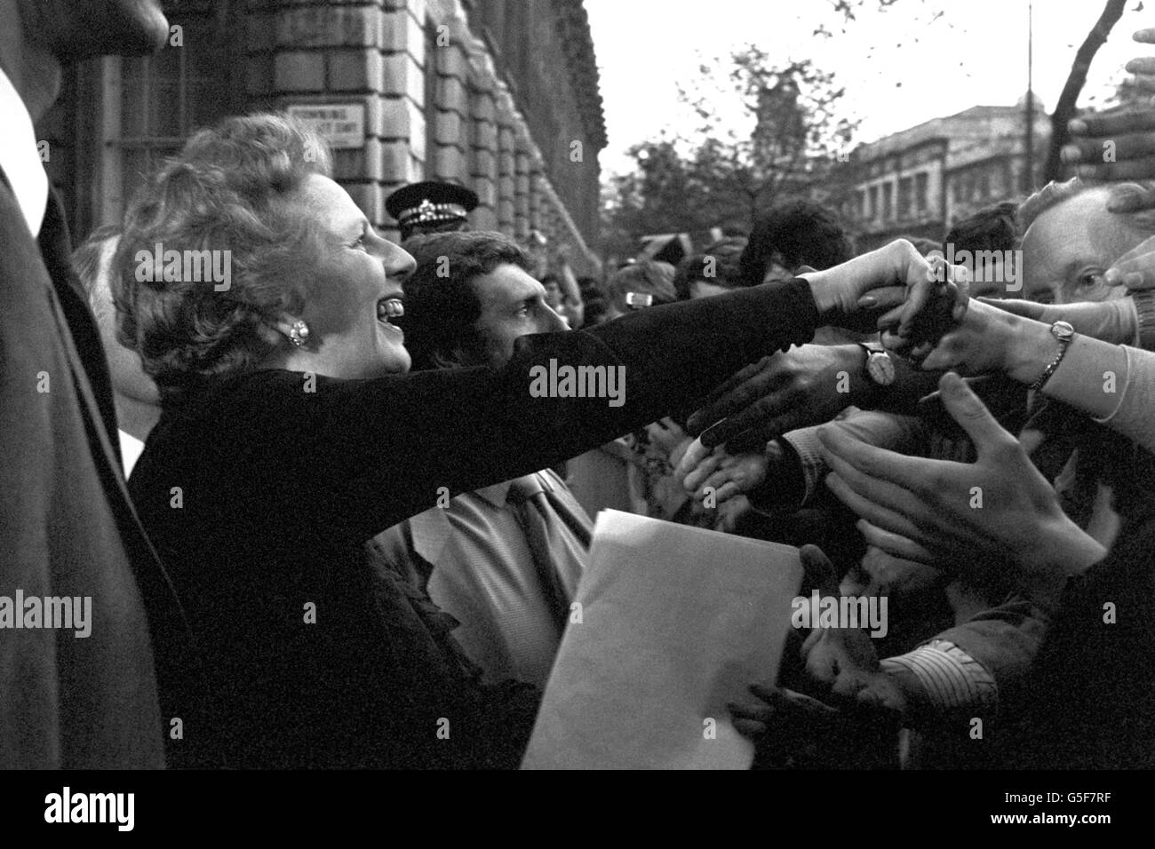 Premierministerin Margaret Thatcher kehrt nach dem Wahlsieg in die Downing Street 10 zurück. Anstatt ihren offiziellen Wohnsitz zu betreten, bestand sie darauf, zum Ende der Straße und zur Ecke von Whitehall zu gehen, um sich die Hände mit den Wohlbejahern zu schütteln. Stockfoto