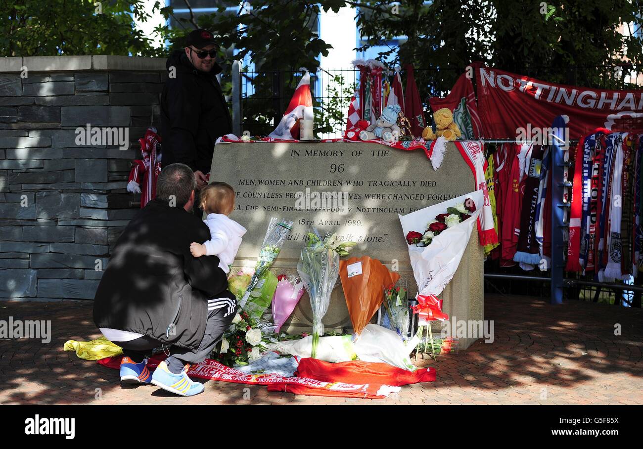 David Roberts aus Liverpool (stehend) vor dem Hillsborough Football Ground in Sheffield, während sein Vater, auch David genannt (links), Kyle Roberts hält, Als die beiden Hillsborough-Überlebenden zum ersten Mal seit 23 Jahren zu Boden kehrten, um sich die Tribute anzusehen, die den 96 Menschen, die bei der Katastrophe ums Leben kamen, hinterlassen wurden. Stockfoto