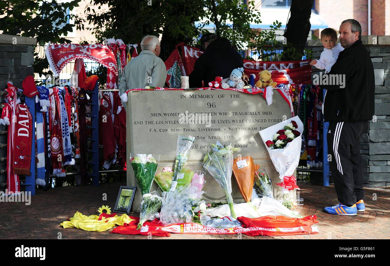 David Roberts aus Liverpool (Mitte, zurück zur Kamera) vor dem Hillsborough Football Ground in Sheffield, während sein Vater, auch David genannt (rechts), Kyle Roberts hält, Als die beiden Hillsborough-Überlebenden zum ersten Mal seit 23 Jahren zu Boden kehrten, um sich die Tribute anzusehen, die den 96 Menschen, die bei der Katastrophe ums Leben kamen, hinterlassen wurden. Stockfoto