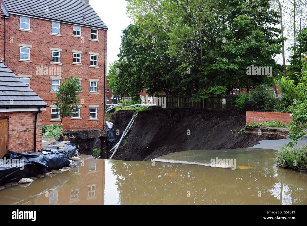 Wasserfällen vorbei an einem Block von Stadthäusern in Newburn, Newcastle, nachdem Überschwemmungen sie in einem Zustand des Einsturzes verlassen, als Flutwasser aus dem Boden unter dem Gebäude, das bleibt abgesperrt inmitten von Sicherheitsbedenken. Stockfoto