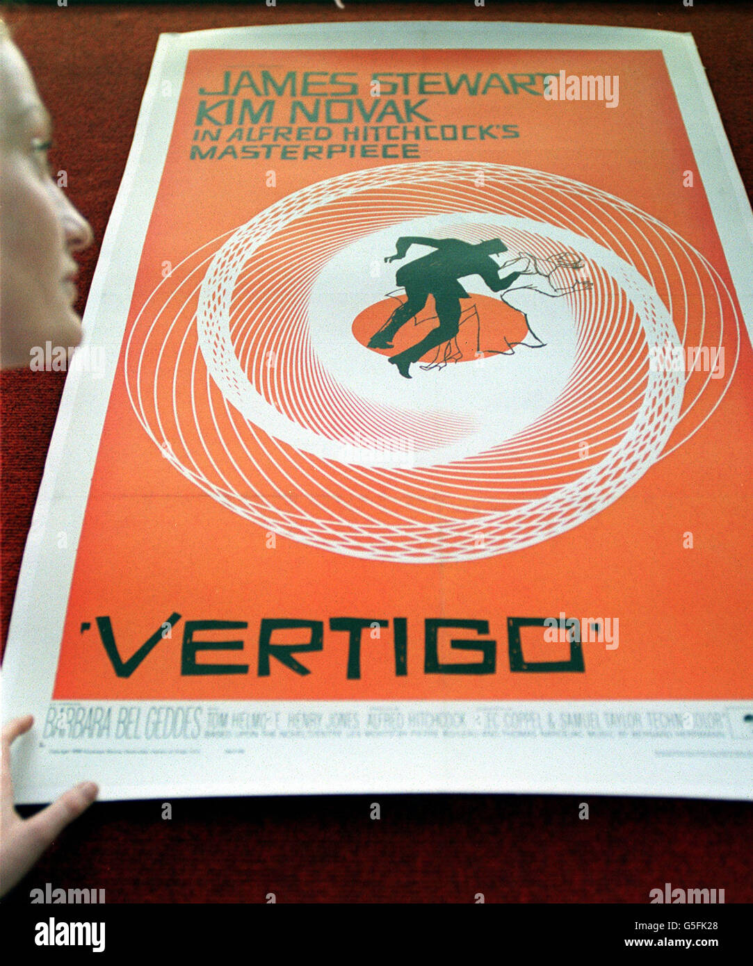 Christies Mitarbeiterin Rachel Dewhurst beim Saul Bass Poster für den Film Vertigo, Teil des Verkaufs der Vintage Film Poster in Christie's South Kensington in London. Das Plakat wird voraussichtlich 700 - 1,000 auf der Auktion. Stockfoto